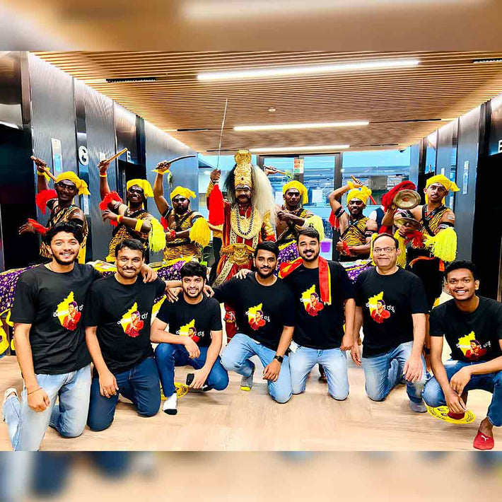 Group of people posing with traditional dancers in a modern indoor setting with WYO  custom T-shirt