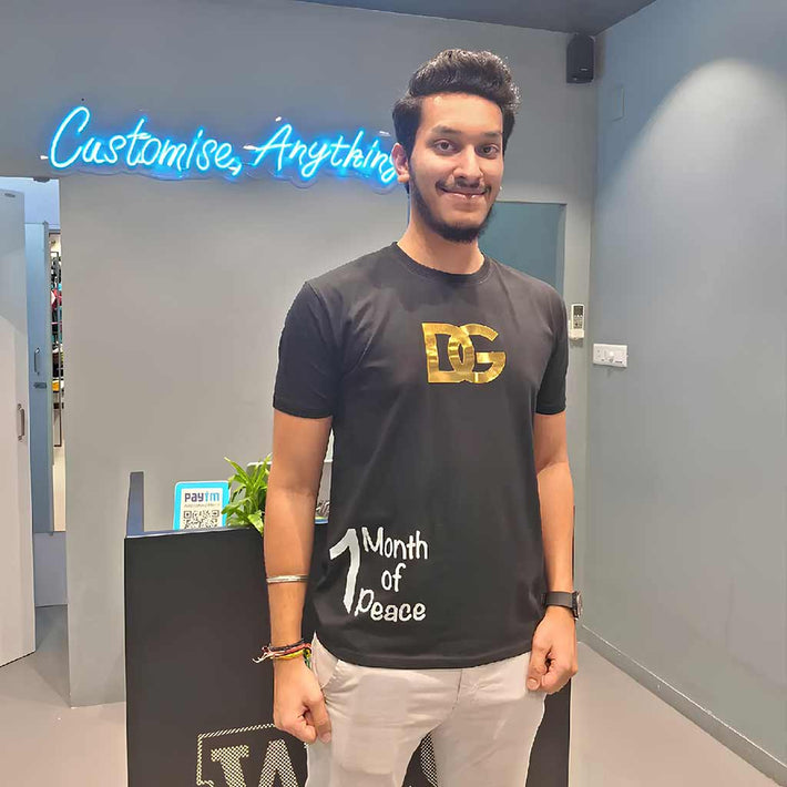 Man wearing a WYO black t-shirt with a gold logo and white text, standing in a modern interior setting.