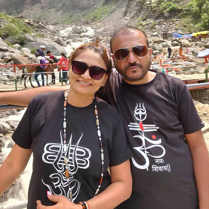 Two people wearing WYO black t-shirts with white designs in a mountainous area.