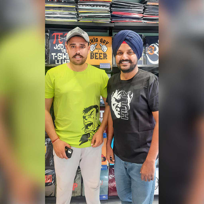 Two men standing in a WYO store with printed t-shirt, shelves in the background