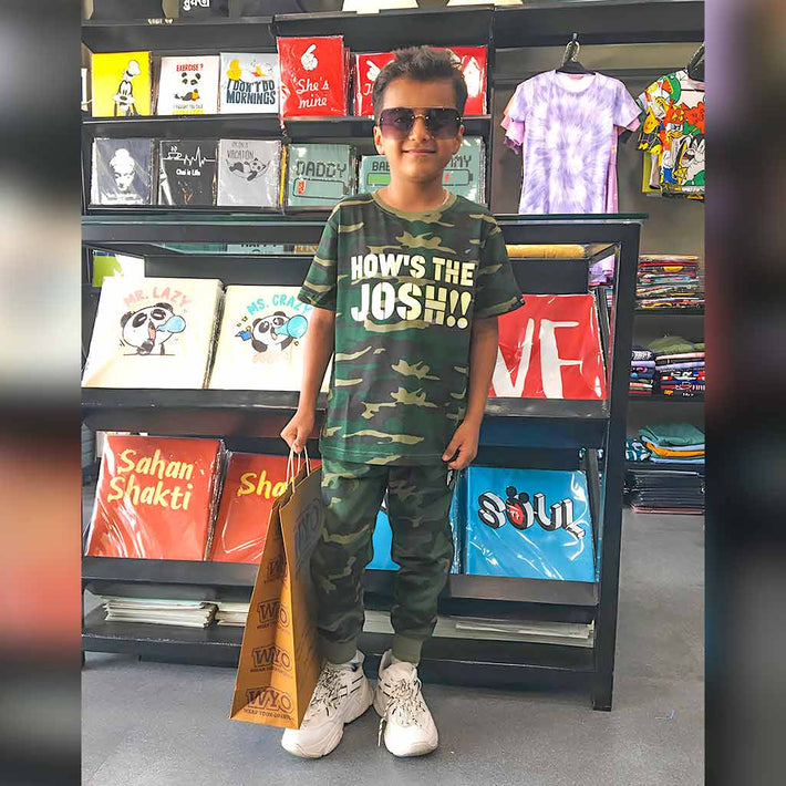 Child wearing a WYO green camouflage outfit with a printed shirt in a store setting