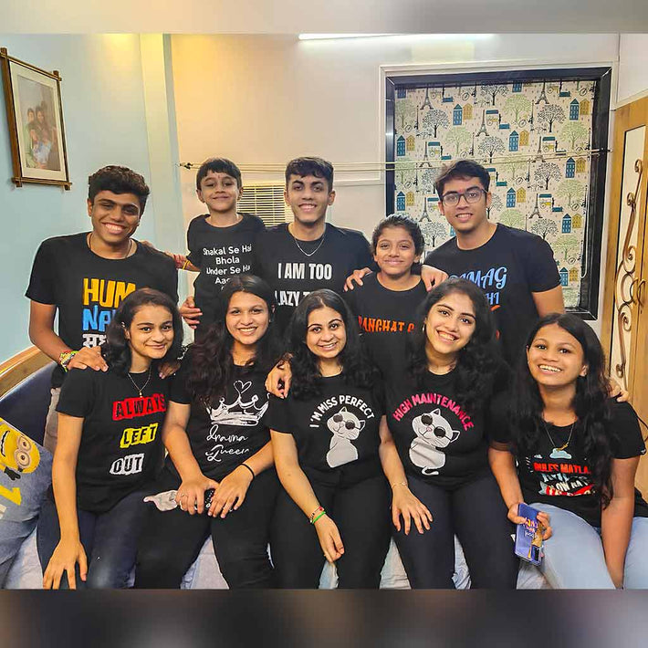 Group of people wearing WYO black t-shirts with various designs and text in a room.