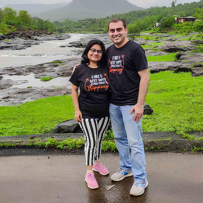 Two people wearing a WYO T-shirt and standing in front of a river with greenery and mountains in the background