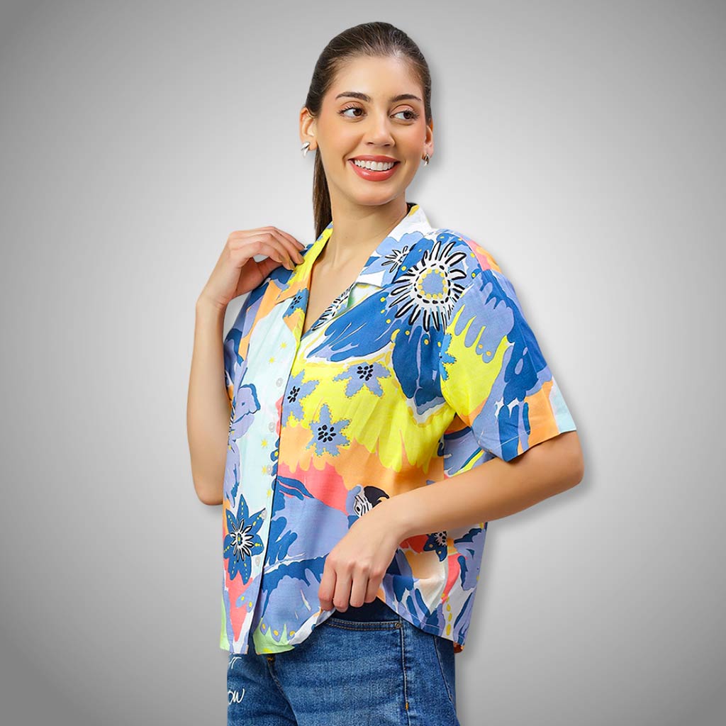 Woman wearing a WYO colorful floral blouse against a gray background