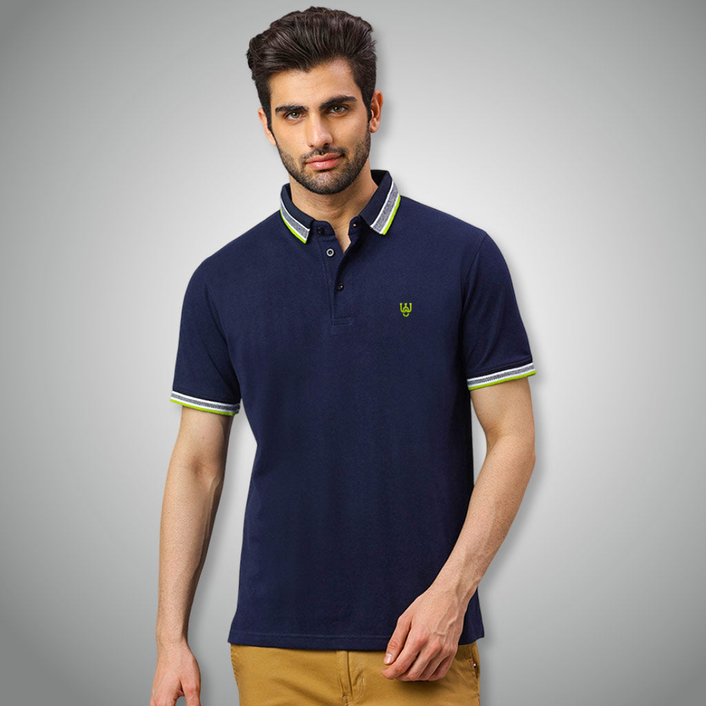Man wearing a WYO navy blue polo shirt with a small logo on a gray background