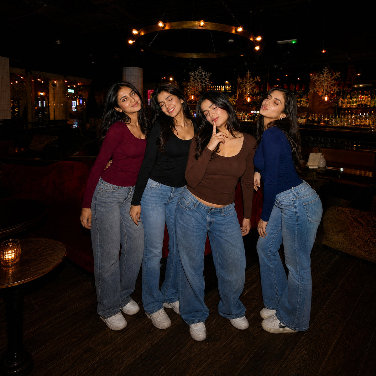 Four women wearing WYO Fitted Full Sleeve T-Shirts in maroon, black, brown, and navy, in a bar setting