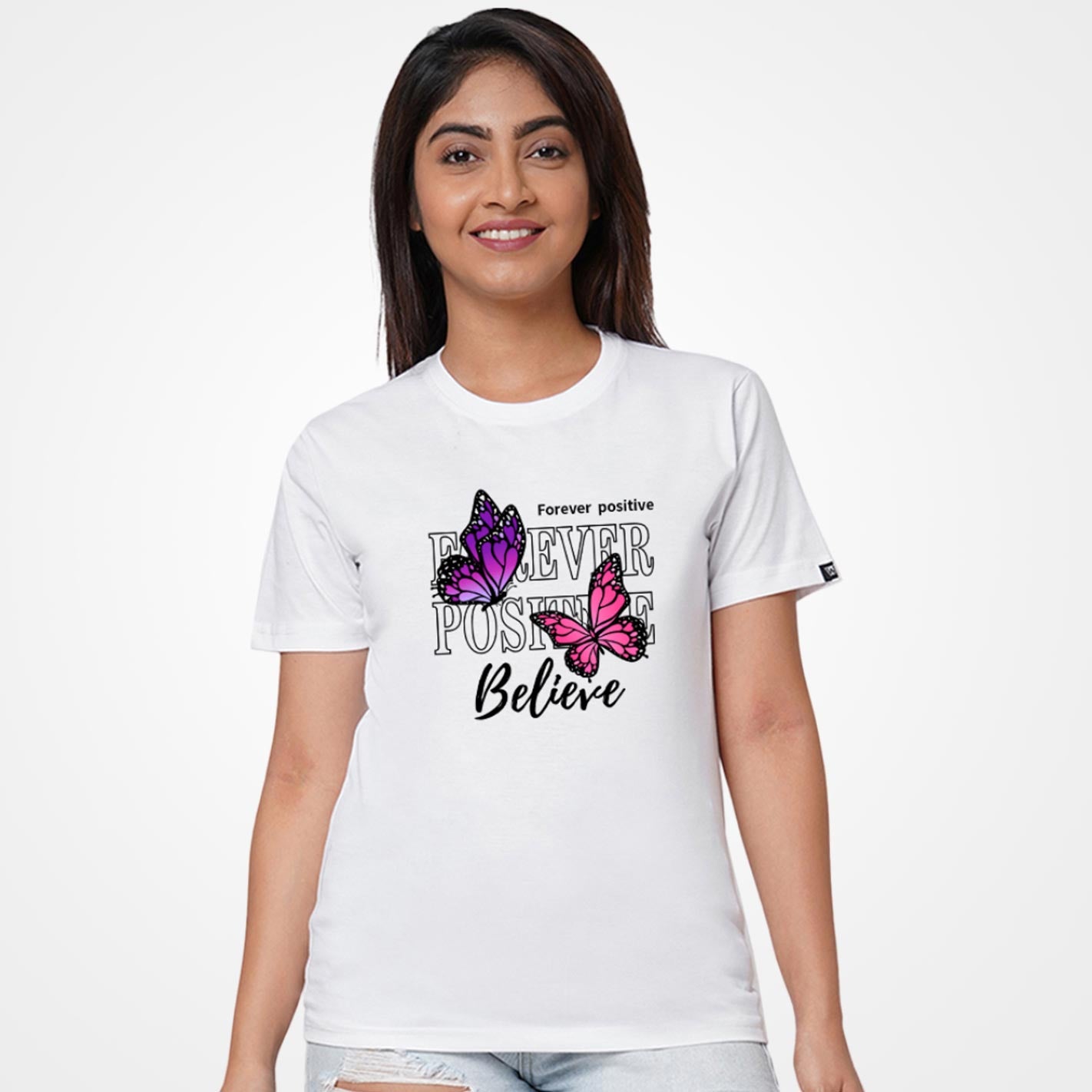 Woman wearing a White t-shirt by WYO with butterfly design and text 'Forever positive Believe' on a white background