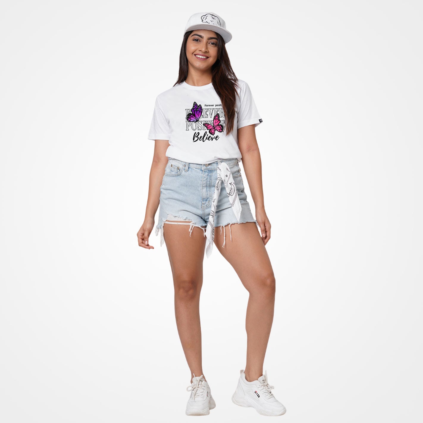 Woman wearing a White t-shirt by WYO with butterfly design and text 'Forever positive Believe' on a white background