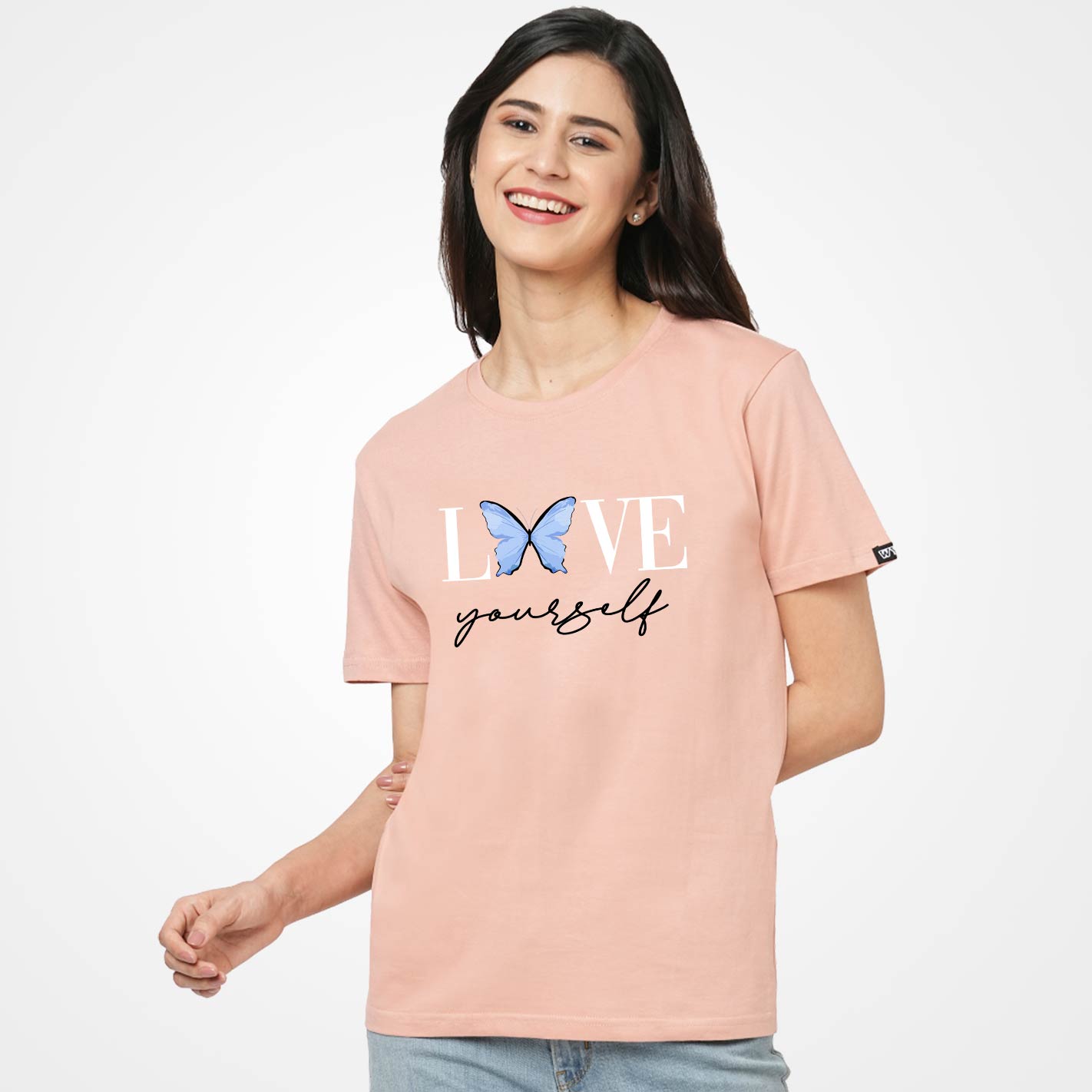 Woman wearing a Peach t-shirt by WYO with 'Love yourself' text and butterfly graphic on a white background