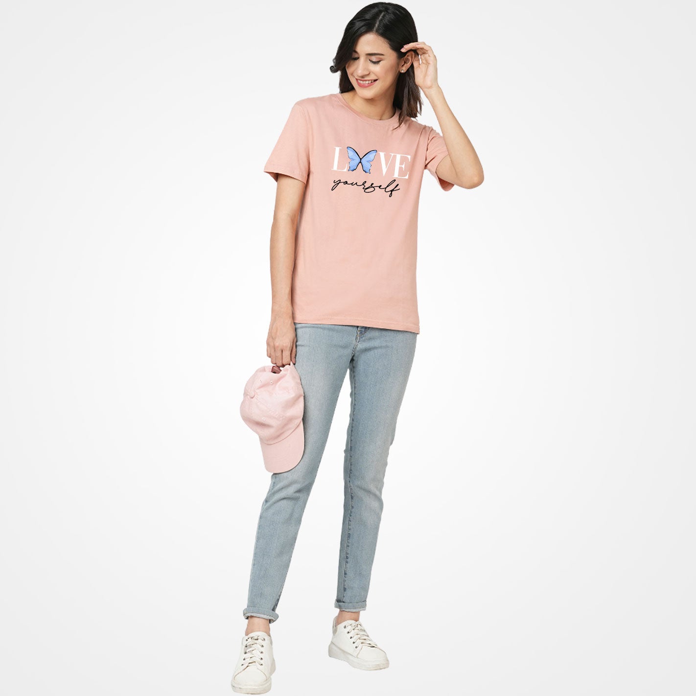 Woman wearing a Peach t-shirt by WYO with 'Love yourself' text and butterfly graphic on a white background
