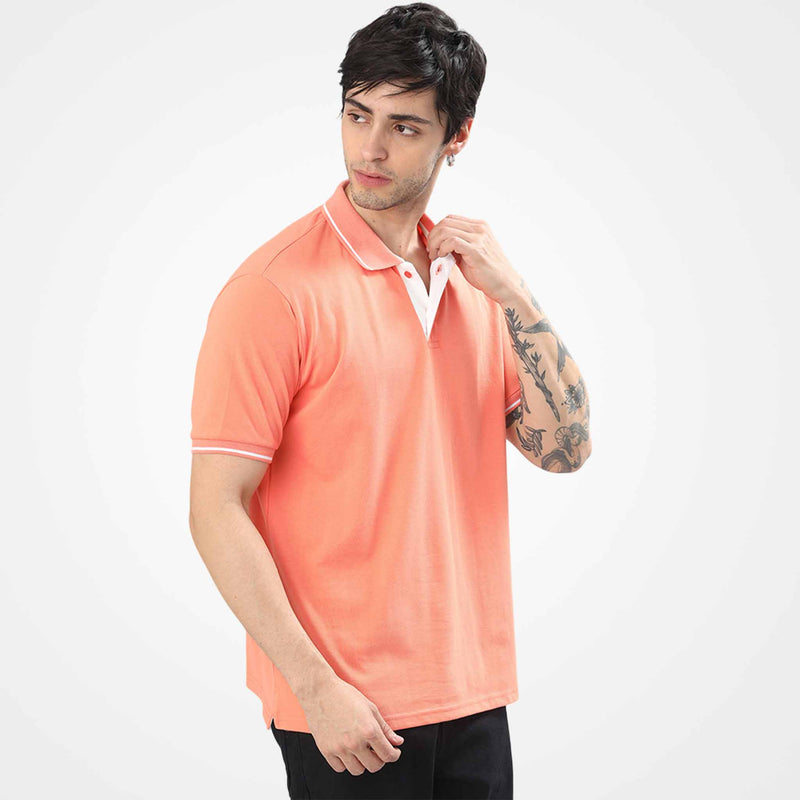 Man wearing a WYO carrot colored polo shirt on a white background
