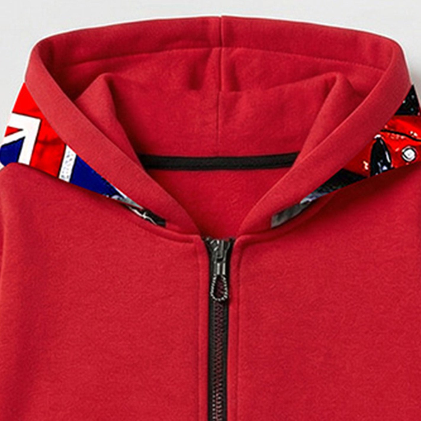 Close-up of a WYO red hoodie with a zipper and patterned lining on a light gray background