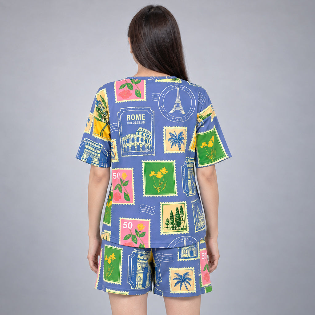 Back view of the blue WYO Travel Tales women’s co-ord set with colorful postcard-style landmarks and floral stamps.